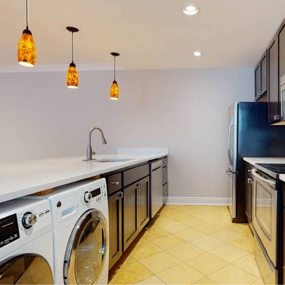 a kitchen with a black refrigerator and white countertops.