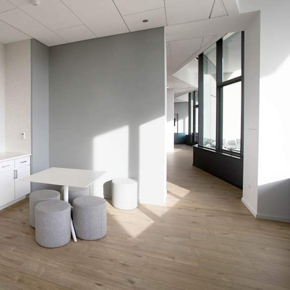 a modern kitchen with white cabinets and a wooden floor.
