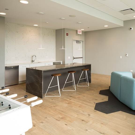 a modern kitchen with a blue sofa and wooden floors.