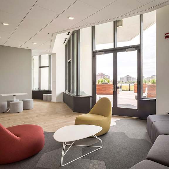 a modern living room with a grey sofa and a yellow chair.