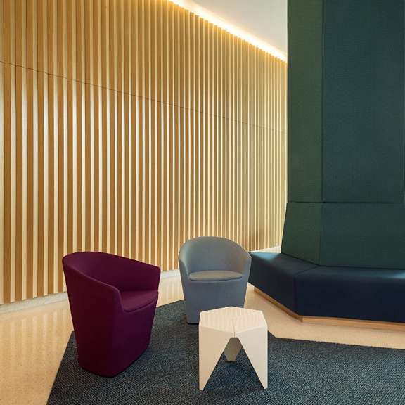 a row of chairs in front of a wooden wall.