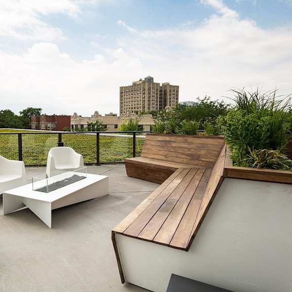 a white chair and table are on a patio with a wooden bench.