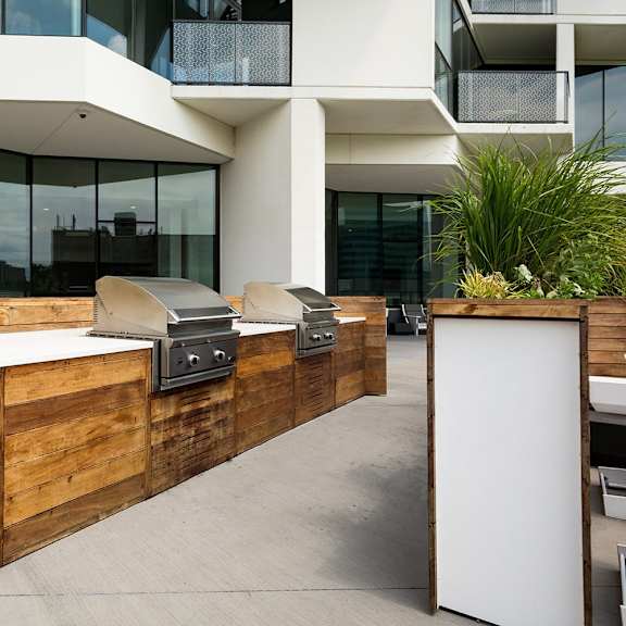 a modern outdoor kitchen with a grill and sink.
