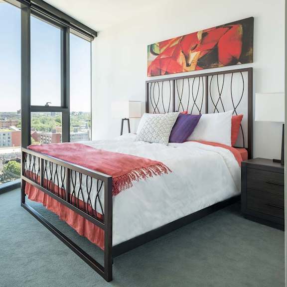 a bedroom with a large bed and a view of the city.