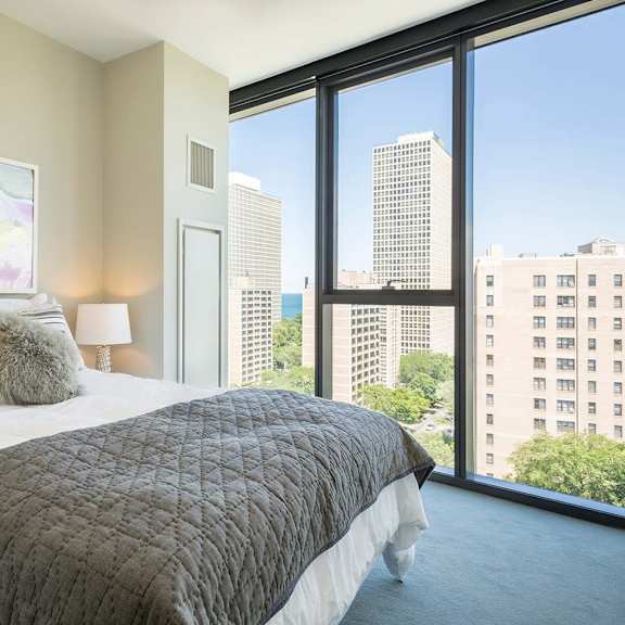 a bedroom with a large bed and a view of the city.