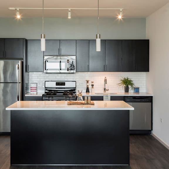 a modern kitchen with a black countertop and stainless steel appliances.