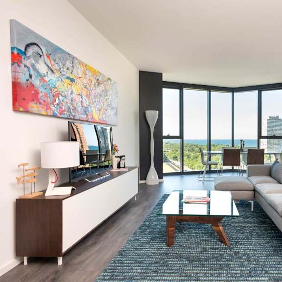 a living room with a couch, a coffee table, and a large painting on the wall.