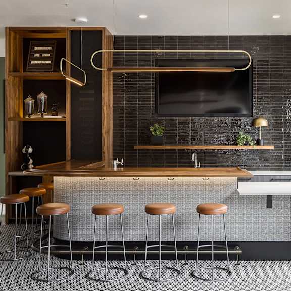a modern kitchen with a bar area and stools.
