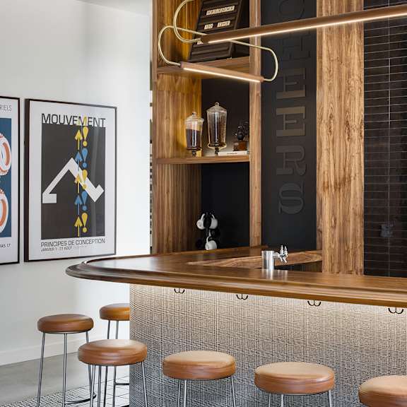 a bar with a wooden shelf and a black and white poster on the wall.