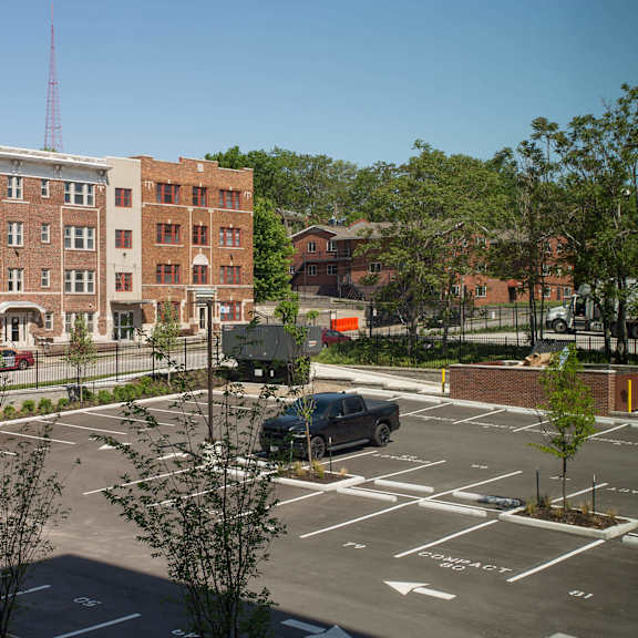 a parking lot with a building and a truck in the background.