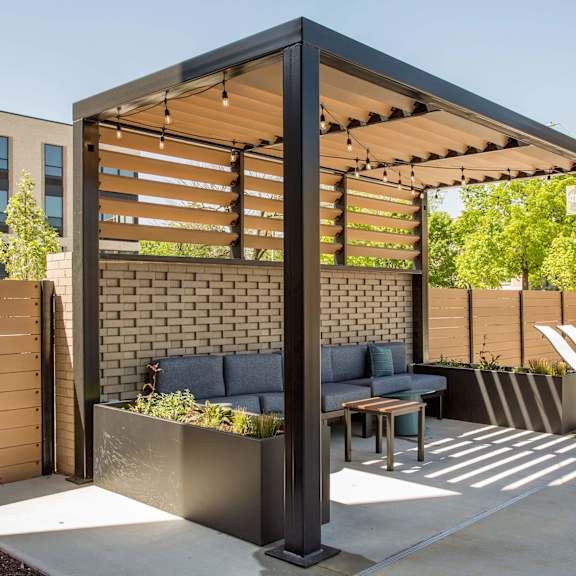 a patio with a table and chairs under a pergola.