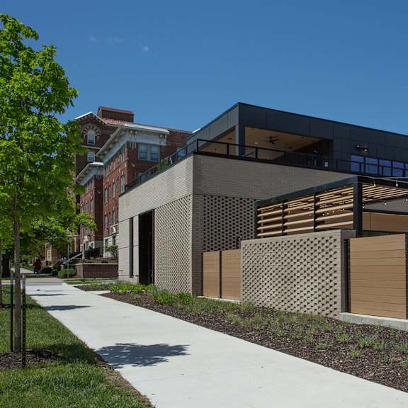 a modern building with a black facade and wooden fence.