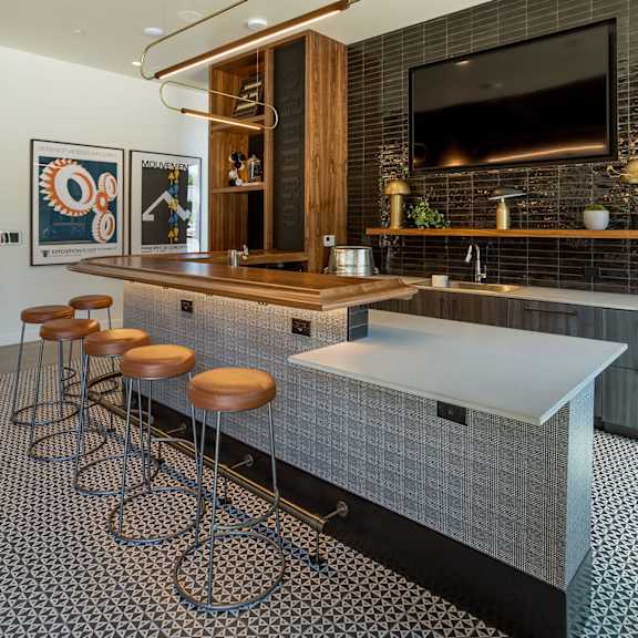 a modern kitchen with a bar area and a television above it.