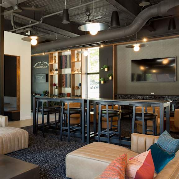 a modern living room with a sofa, coffee table, and a bar area.