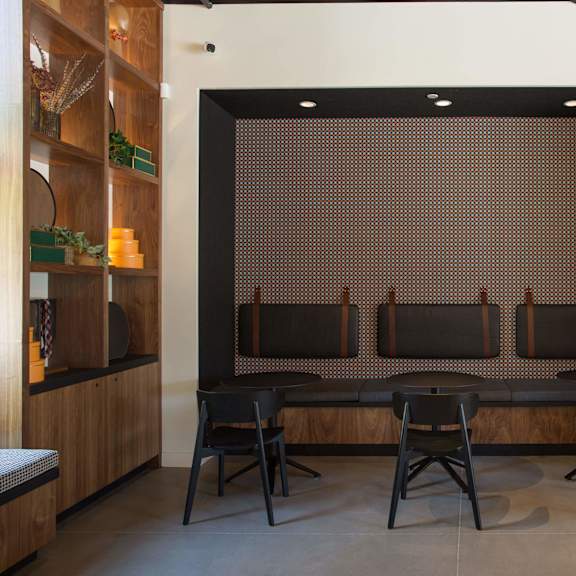 a room with a brown patterned screen and black chairs.
