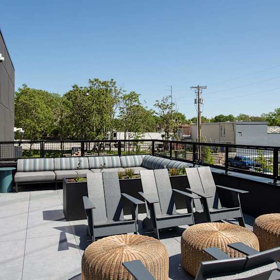 a patio with grey chairs and tables.