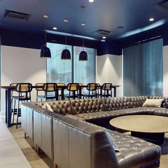 a black and brown leather couch with a round table in front of it.