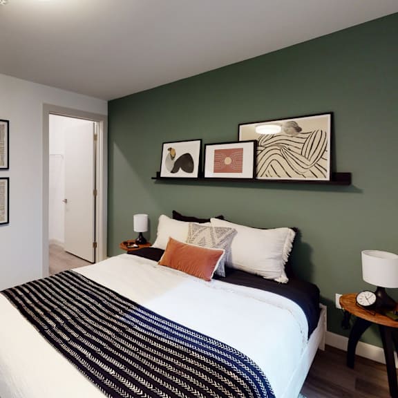 a bedroom with a large bed and a green wall.