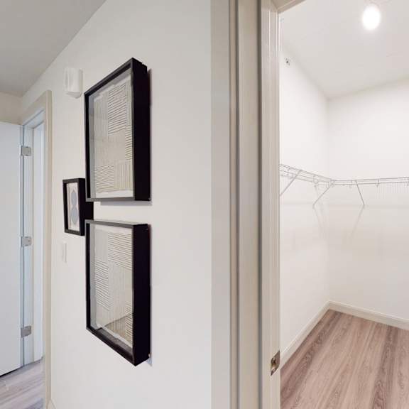 a white room with a wooden floor and a clothesline.