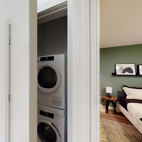 a washer and dryer are built into a wall in a living room.