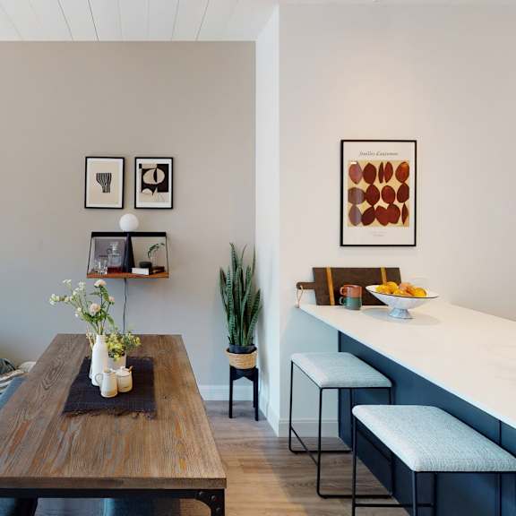 a living room with a couch, a coffee table, and a kitchen area.