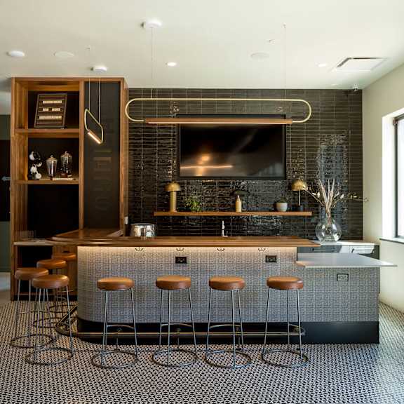 a modern kitchen with a bar area and stools.
