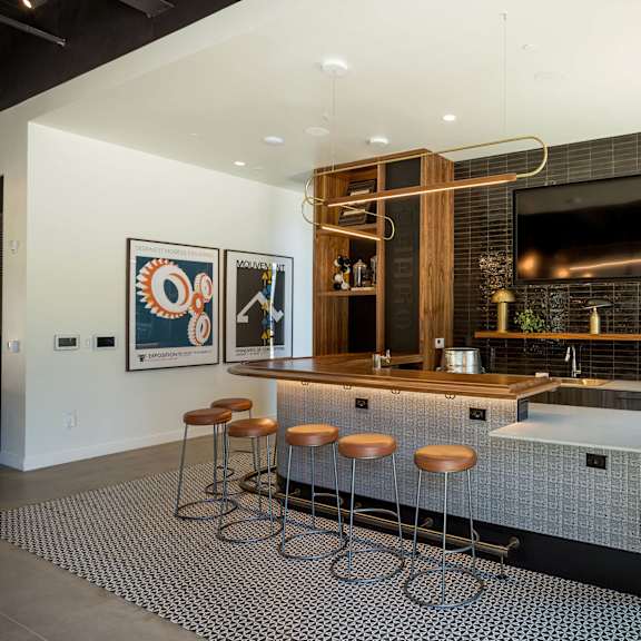 a modern kitchen with a bar area and stools.