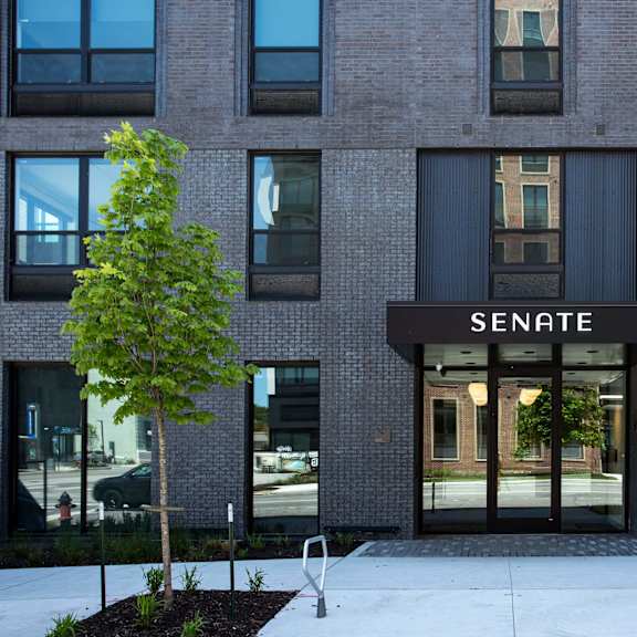 a modern building with a black awning that says "senate" on it.