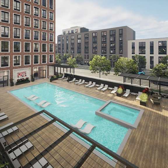a pool surrounded by chairs and a wooden deck.