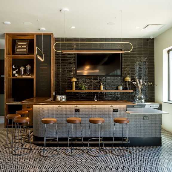 a modern kitchen with a bar area and stools.