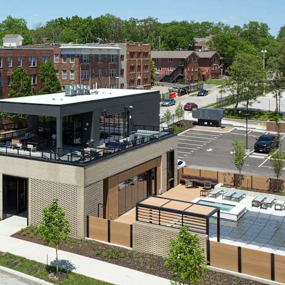 a modern building with a glass entrance sits in front of a parking lot.