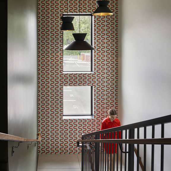 a man in a red shirt is walking down a staircase.