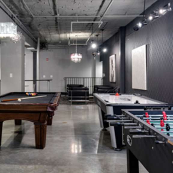 a billiards room with a pool table and air conditioning pipes.