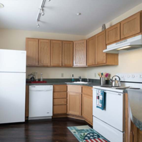 a kitchen with wooden cabinets and a white fridge.