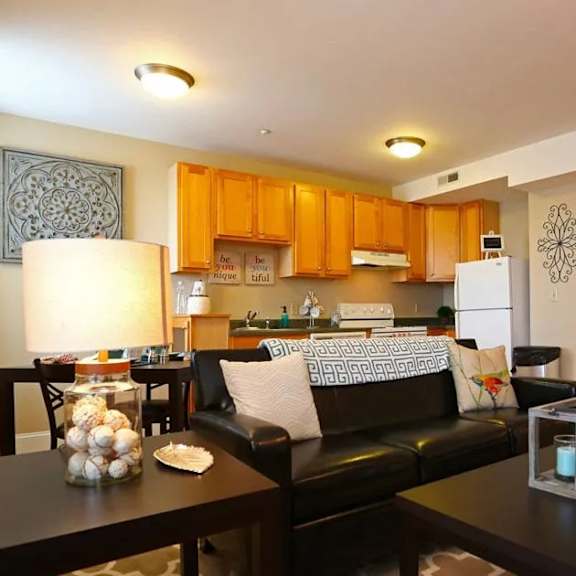 a living room with a black couch and a coffee table with a candle holder on it.