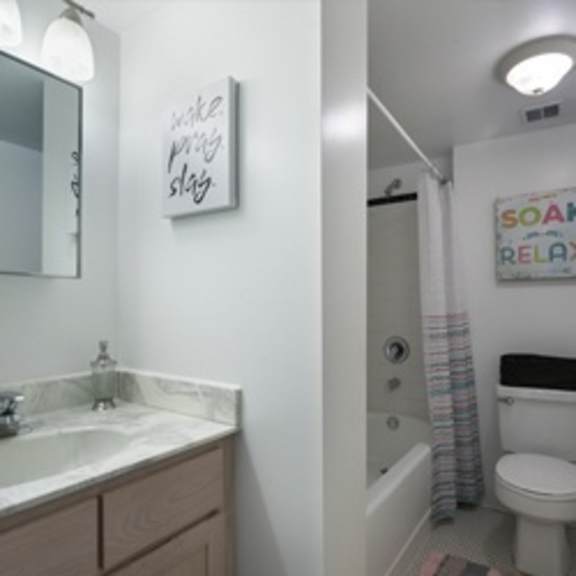 a bathroom with a toilet, sink and a shower.