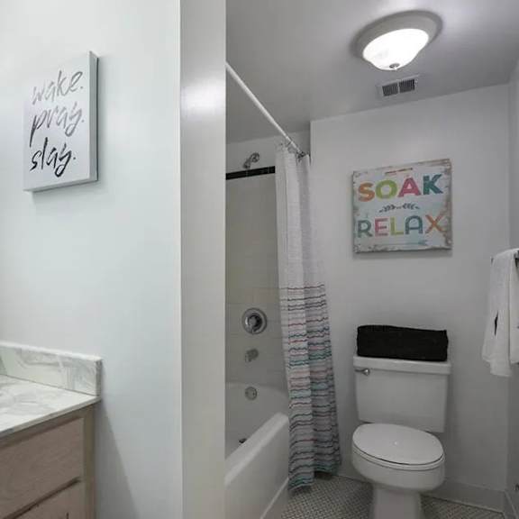 a bathroom with a white toilet and a white sink.