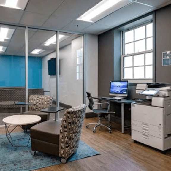 a room with a table and chairs and a computer.
