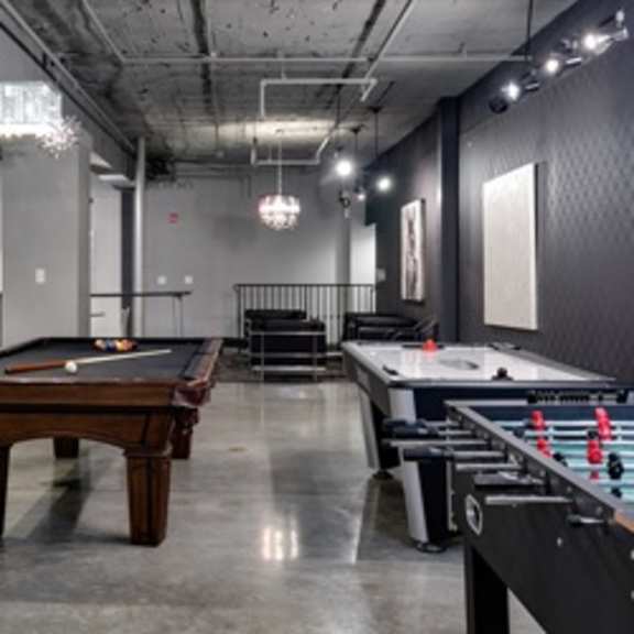 a room with a pool table and a foosball table.