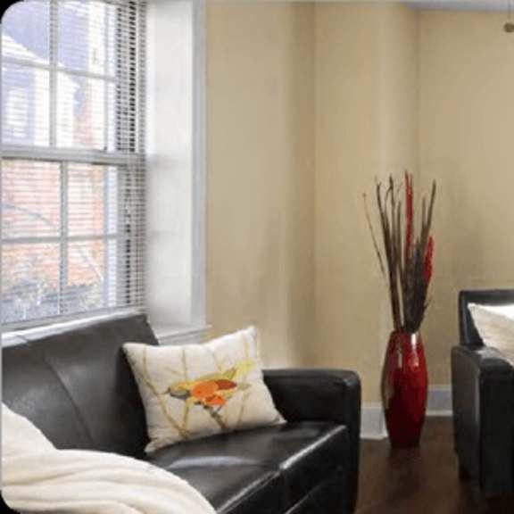 a living room with a black couch and a dining table.