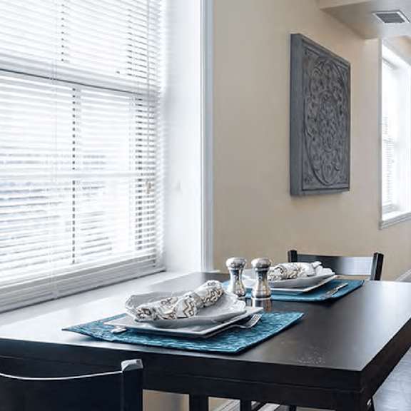 a dining table with chairs and a decorative piece on the wall.