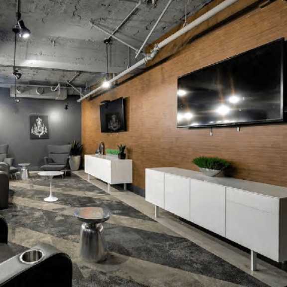 a modern living room with a large tv on the wall.