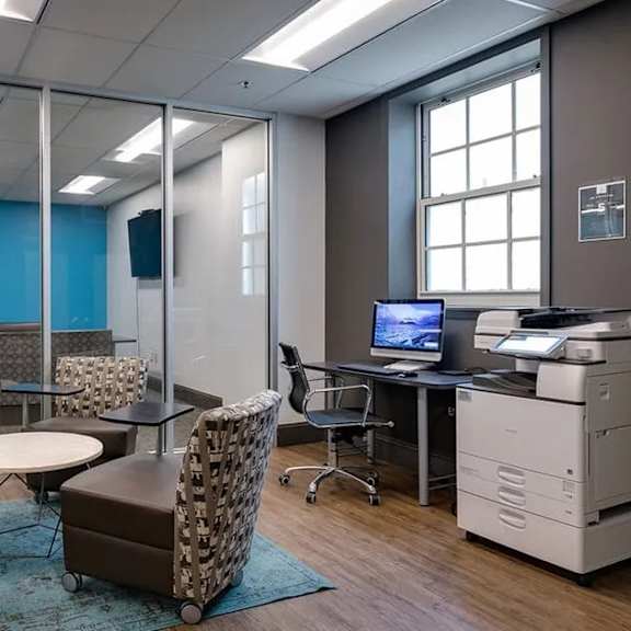 a room with a table, chairs, and a computer.
