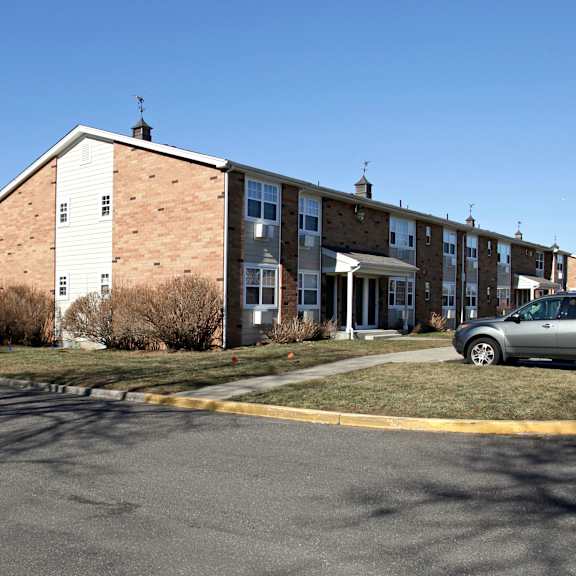 a parking lot in front of a building with a car parked.