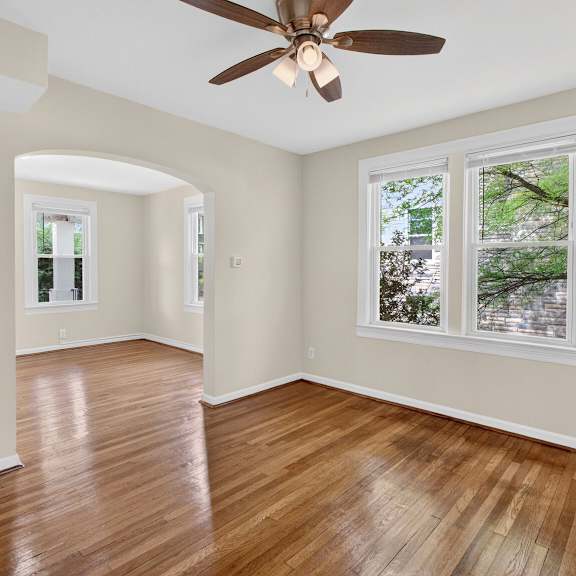 a room with a ceiling fan and hardwood floors.