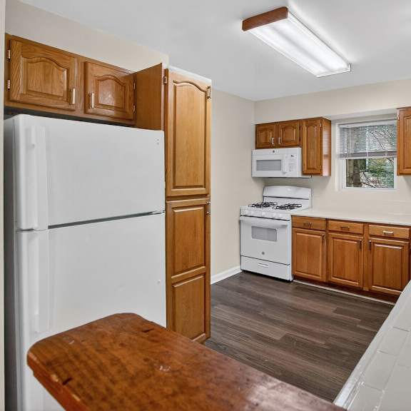 a kitchen with wooden cabinets and a white refrigerator.