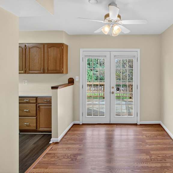 a room with a ceiling fan and a door leading to a patio.