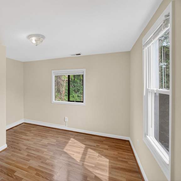 a room with a white door and a window with a view of trees.