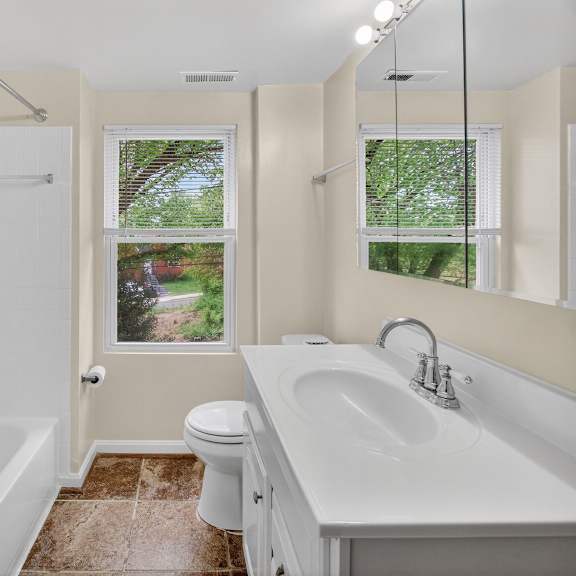 a bathroom with a white tub, toilet, and sink.