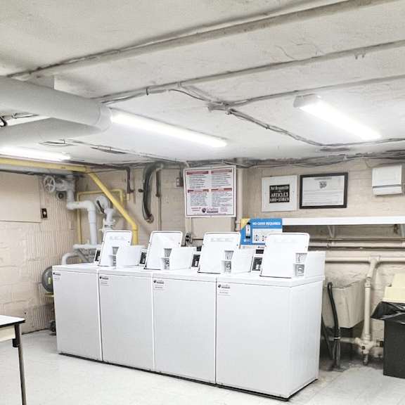a room with white cabinets and a table, and a yellow pipe.